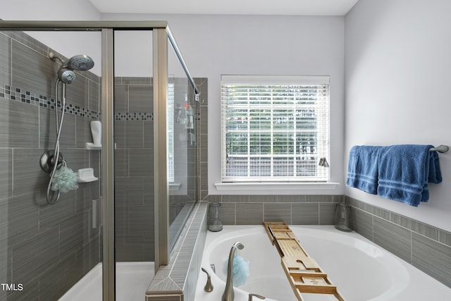 full bathroom featuring a shower stall and a bath