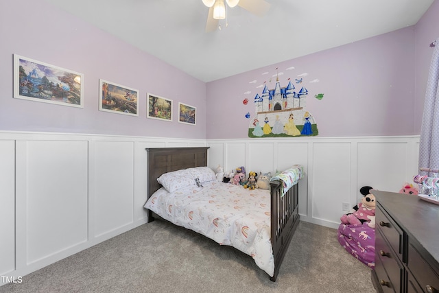 bedroom featuring wainscoting, carpet, and a decorative wall