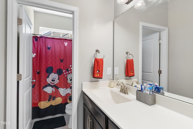 bathroom featuring toilet, curtained shower, and vanity