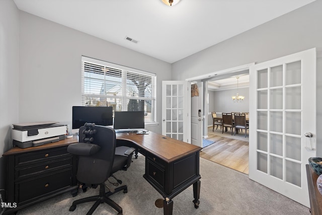 carpeted office space featuring french doors, wood finished floors, visible vents, and an inviting chandelier