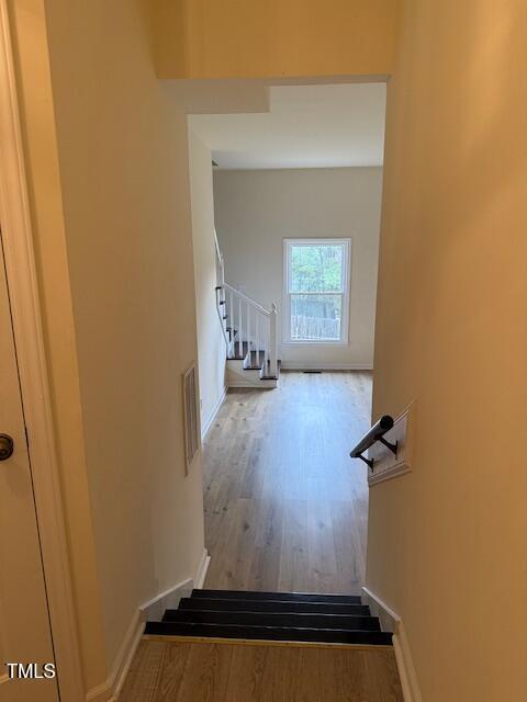 stairs featuring visible vents, baseboards, and wood finished floors