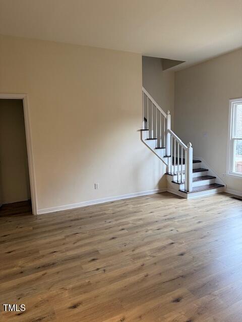 interior space featuring stairway, wood finished floors, and baseboards