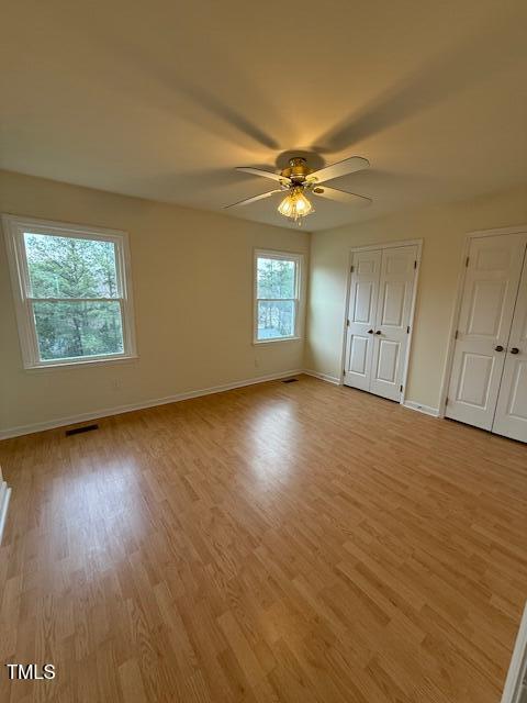 unfurnished bedroom featuring visible vents, light wood-style flooring, baseboards, and ceiling fan