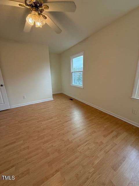 empty room featuring visible vents, baseboards, light wood-style flooring, and a ceiling fan