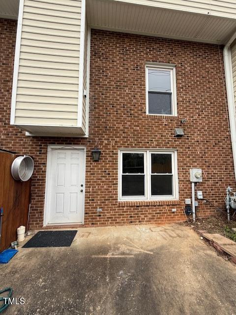 view of exterior entry featuring brick siding