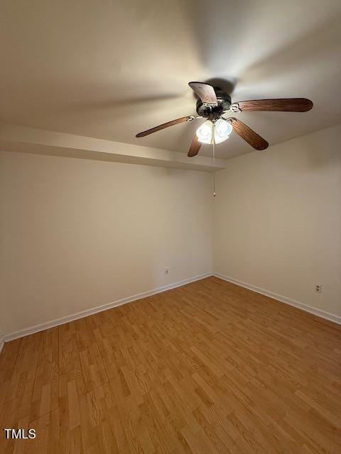 unfurnished room with a ceiling fan, baseboards, and light wood-type flooring