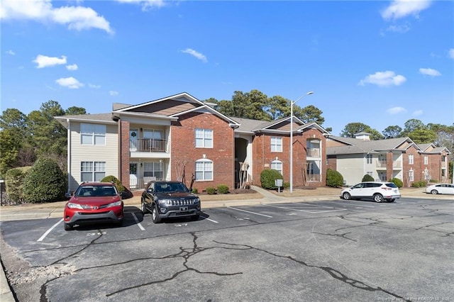 view of building exterior with uncovered parking and a residential view