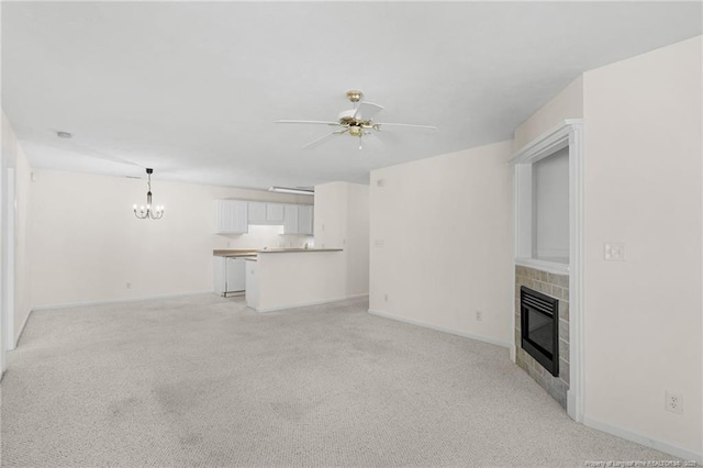 unfurnished living room featuring light colored carpet, ceiling fan with notable chandelier, baseboards, heating unit, and a tiled fireplace