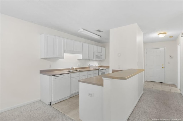 kitchen featuring white appliances, a sink, visible vents, and white cabinetry