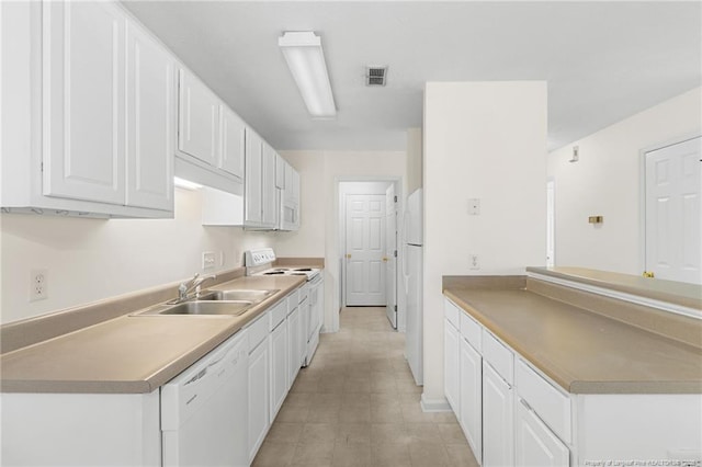 kitchen featuring white appliances, visible vents, a sink, and white cabinetry