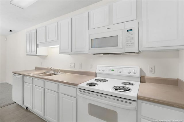 kitchen with white appliances, visible vents, white cabinets, light countertops, and a sink