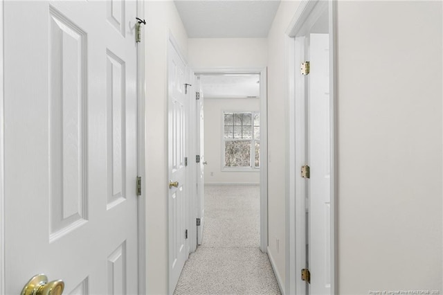 corridor with light carpet and baseboards