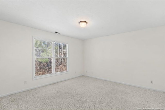 carpeted empty room with visible vents and baseboards