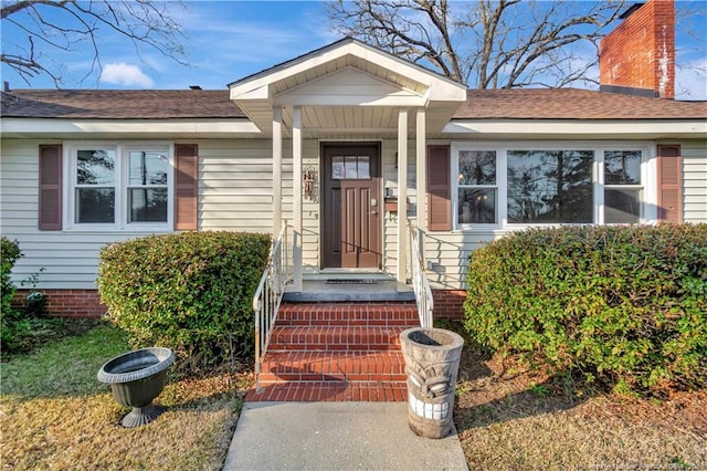 entrance to property featuring a shingled roof and crawl space