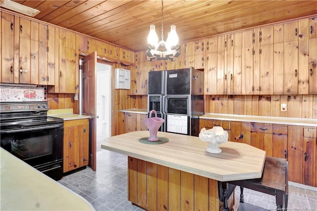 kitchen with a chandelier, wood walls, wood ceiling, light countertops, and black appliances