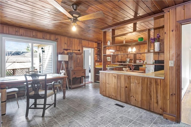 kitchen featuring wooden walls, wood ceiling, visible vents, open shelves, and brown cabinetry