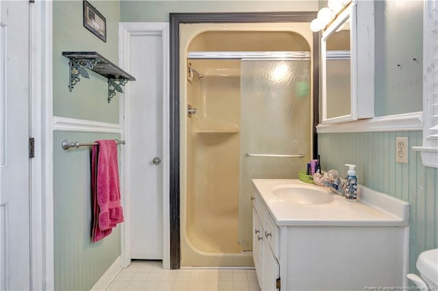 bathroom featuring toilet, a stall shower, and vanity