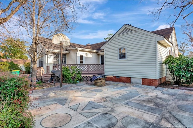 back of property featuring a patio and a deck