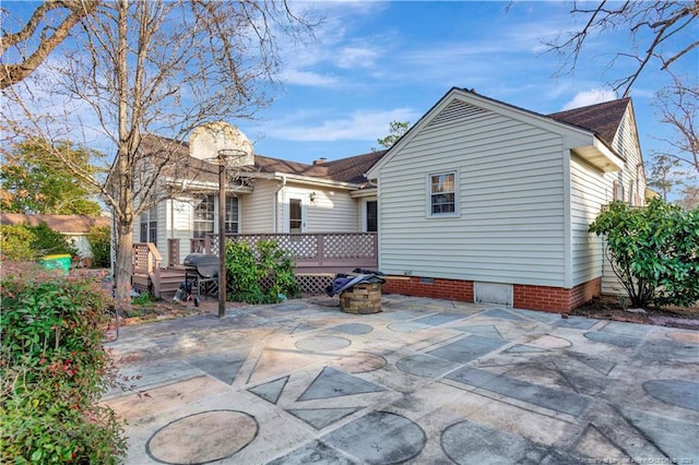 504 W 30th St, Lumberton, NC 28358 - rear view of house with a wooden deck, a patio area, crawl space, and a fire pit