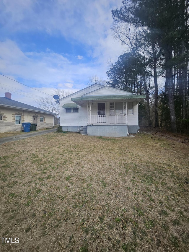 view of front facade featuring covered porch and a front lawn