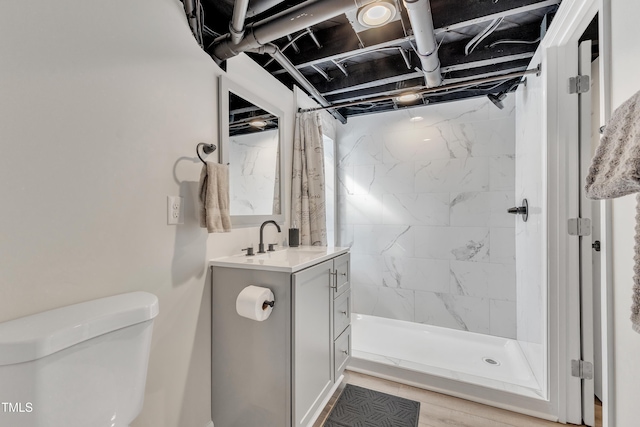 bathroom with a stall shower, vanity, and toilet