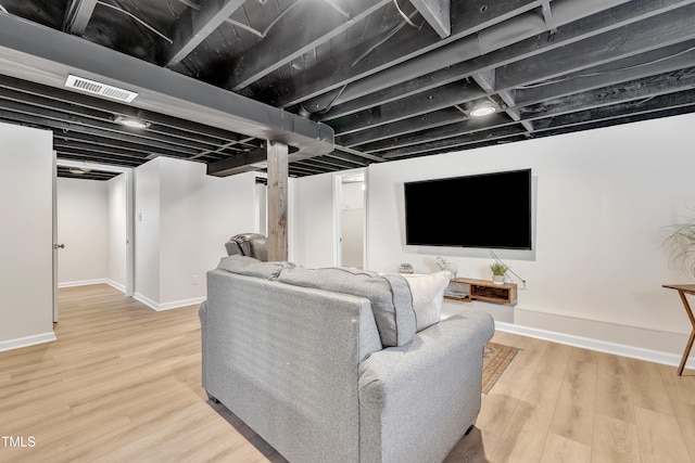 living room with wood finished floors, visible vents, and baseboards