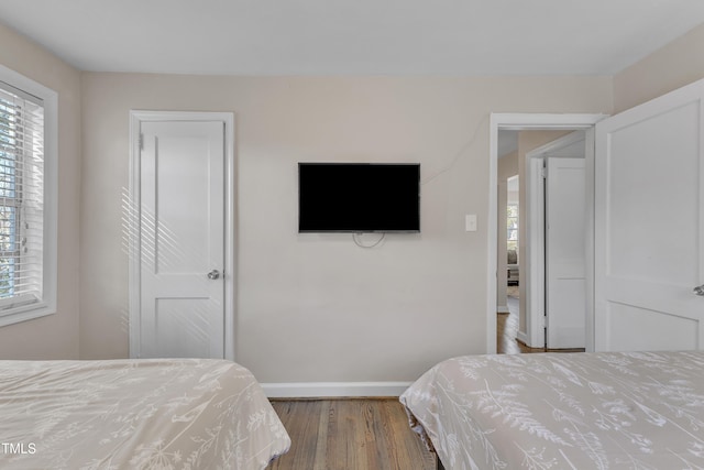 bedroom featuring baseboards and wood finished floors