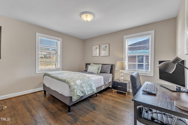 bedroom with dark wood finished floors and baseboards