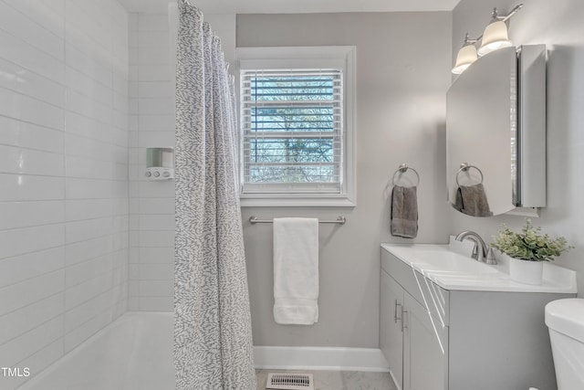 full bathroom with toilet, vanity, visible vents, baseboards, and shower / bath combo