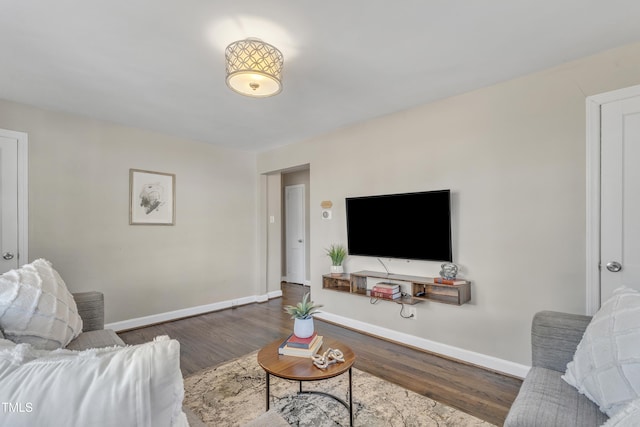 living area with baseboards and wood finished floors