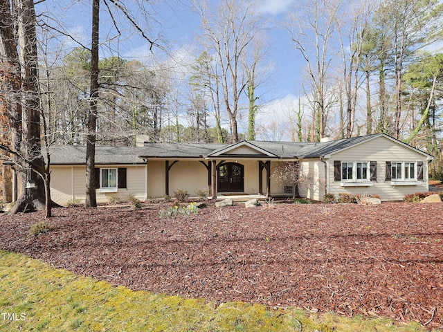 ranch-style home with roof with shingles