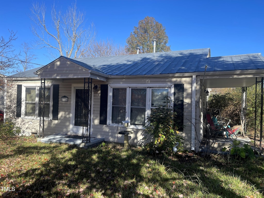 view of front of house featuring a front lawn and metal roof