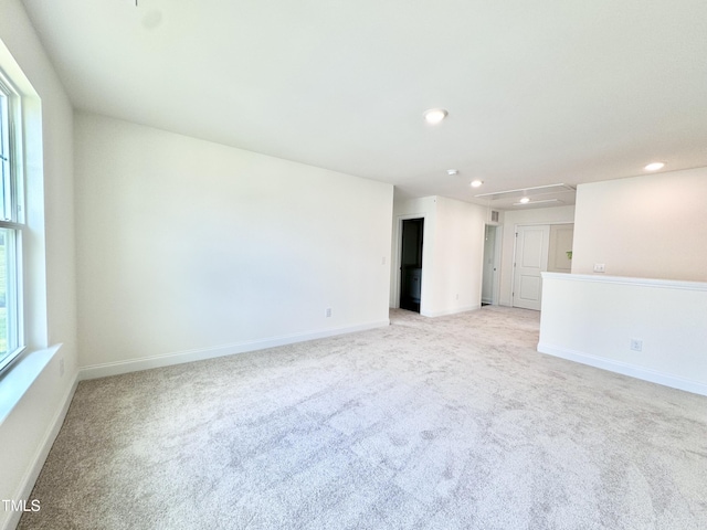 spare room featuring light carpet, baseboards, and recessed lighting