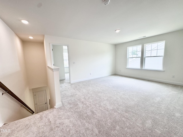 carpeted spare room featuring recessed lighting, visible vents, and baseboards