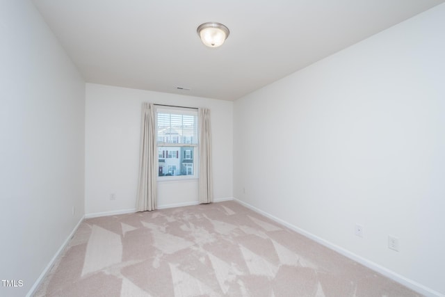 unfurnished room featuring light colored carpet and baseboards