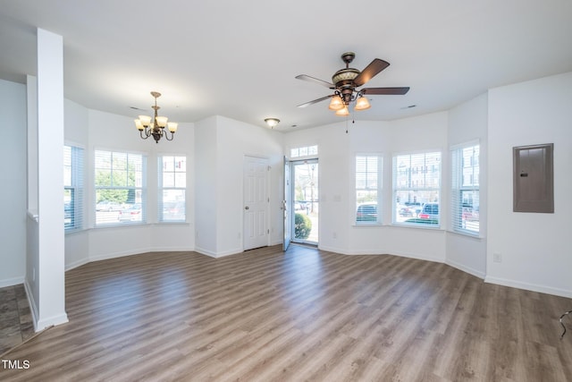 unfurnished living room with a wealth of natural light, electric panel, and wood finished floors