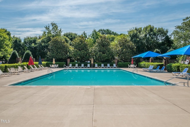 pool with a patio and fence