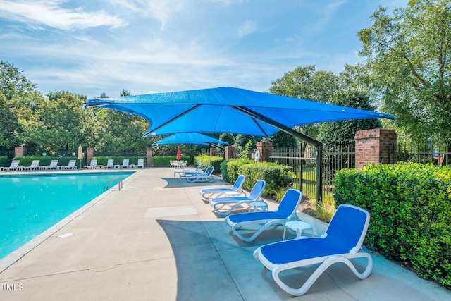 community pool featuring fence and a patio