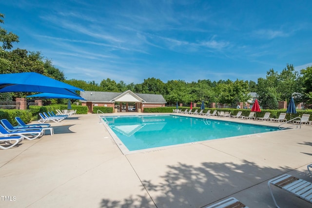 community pool with a patio area and fence