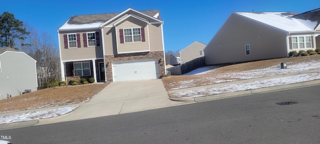 view of front of home with a garage, stone siding, and driveway