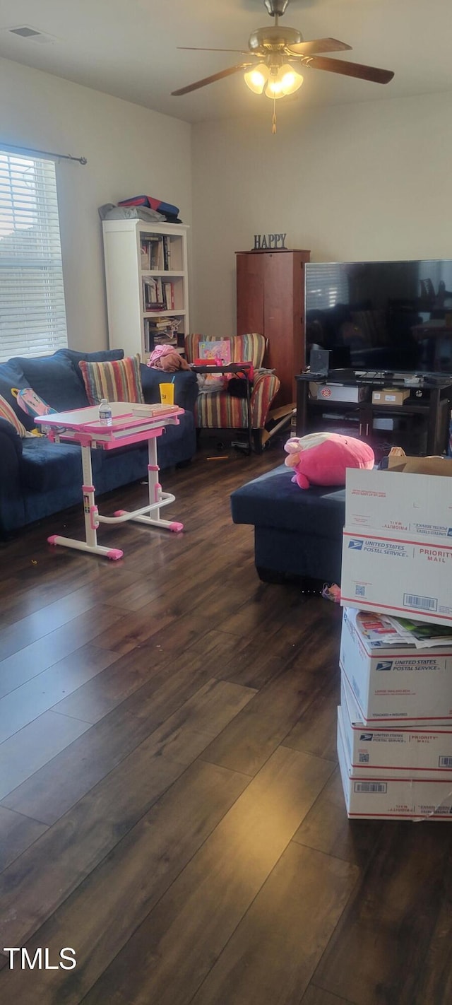 living area with lofted ceiling, wood finished floors, and a ceiling fan