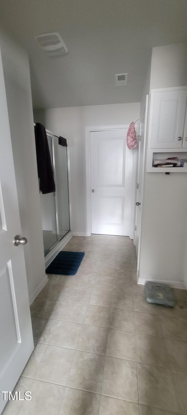 bathroom featuring a stall shower, baseboards, and visible vents