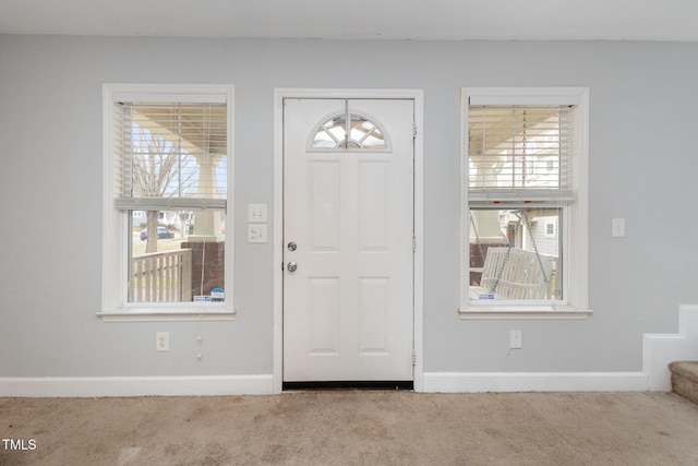 carpeted entrance foyer featuring baseboards