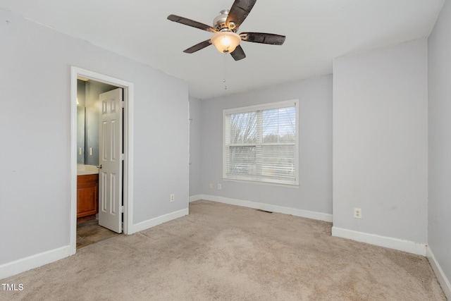 unfurnished bedroom with visible vents, connected bathroom, baseboards, light colored carpet, and ceiling fan