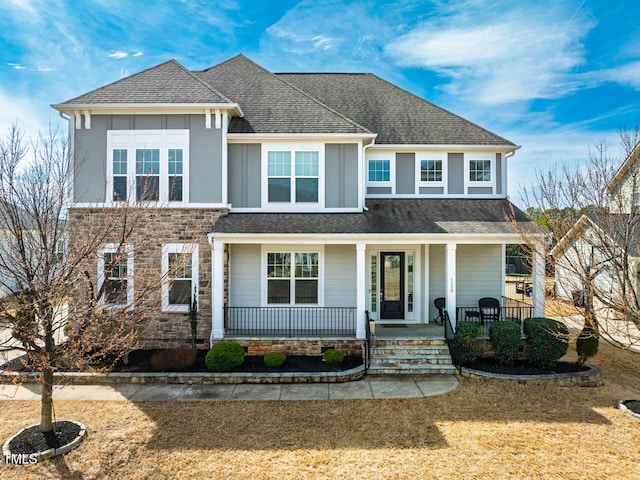 view of front of home with stucco siding, covered porch, and a shingled roof