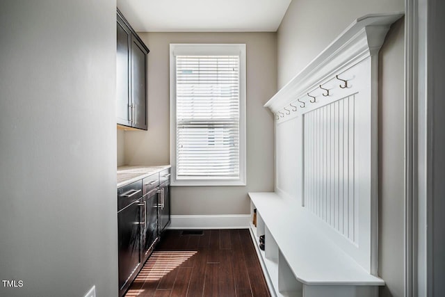 mudroom with dark wood-style floors and baseboards