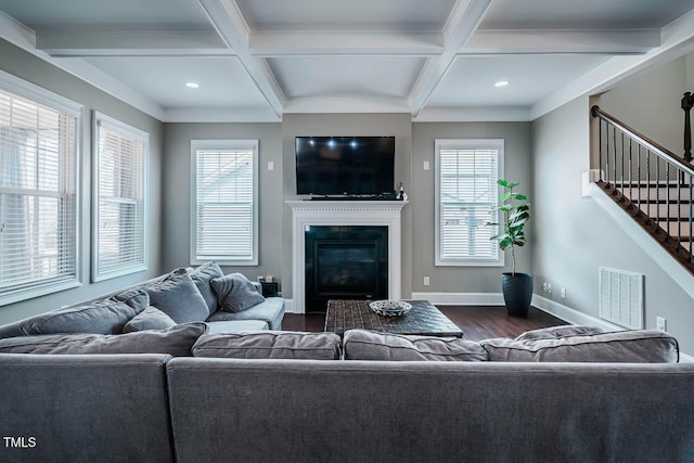 living room featuring visible vents, dark wood-type flooring, baseboards, stairs, and a glass covered fireplace