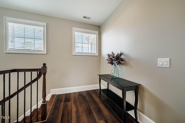 stairs featuring wood finished floors, baseboards, visible vents, and vaulted ceiling