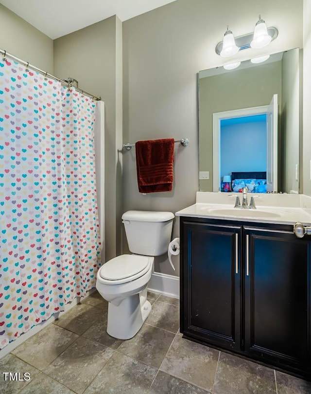 bathroom featuring vanity, baseboards, stone finish flooring, curtained shower, and toilet