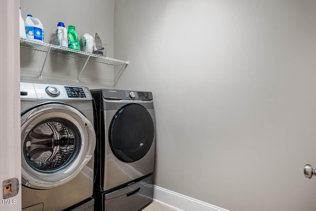 laundry area with baseboards, laundry area, and washer and clothes dryer